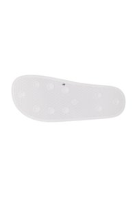 Semelle de chaussure en caoutchouc blanc avec une surface texturée, des points de grip en relief et un contour lisse avec une légère courbure au niveau des orteils.