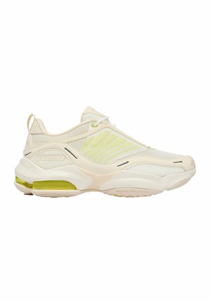 Jasnobeżowy sportowy sneaker z cholewką z siateczki, grubą podeszwą, widoczną żółtą poduszką powietrzną w pięcie oraz pętelką z tyłu.