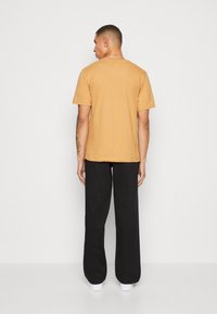 Nike Sportswear CLUB TEE - T-shirt básica - gold