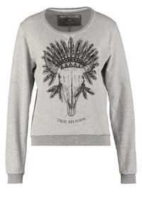 Sweat-shirt gris clair avec un crâne de taureau noir portant une coiffe de plumes et le texte « True Religion » sous le dessin.