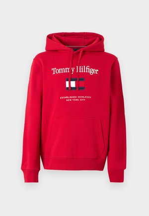 Red hoodie with front pocket, drawstrings, and white "Tommy Hilfiger" text above a red, white, and navy flag logo and smaller text below.
