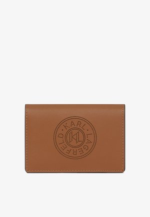Brown leather cardholder with circular perforated logo design centered on front flap, smooth texture, and visible stitching along edges.