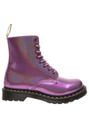 Botte de combat métallique violette à lacets avec semelle noire et coutures jaunes, avec languette à l’arrière.