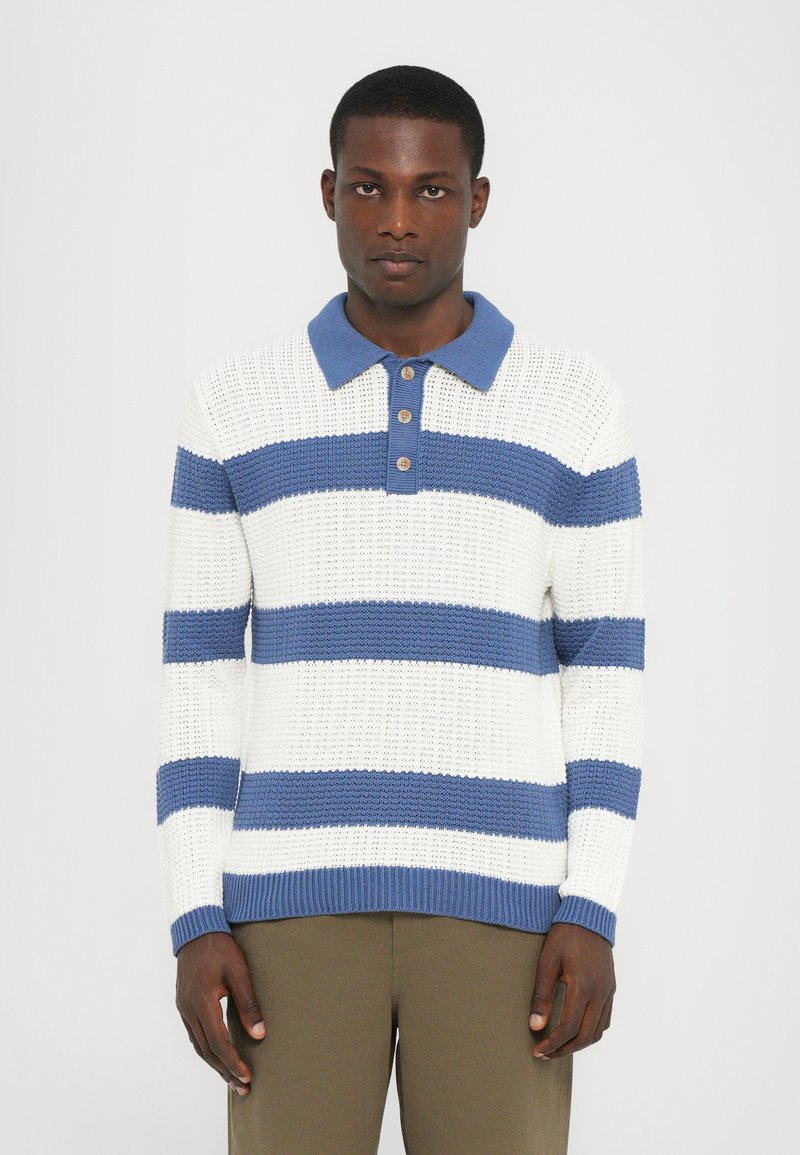 Strikket polo-genser med hvite og blå horisontale striper, med en blå krage og tre brune knapper, i et teksturert stoff.