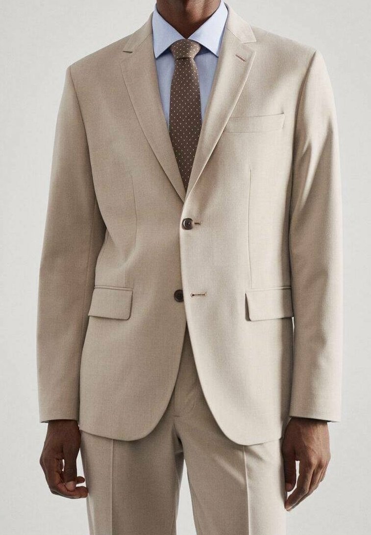 Beige pak met twee knopen, ingeknipte revers, en twee voorzakken. Vergezeld van een lichtblauw overhemd en een bruine stropdas met stippen.