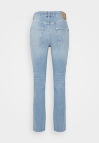 Jeans de denim azul claro com corte straight leg, design de cinco bolsos e um patch de couro castanho na parte de trás da cintura. Textura suave.