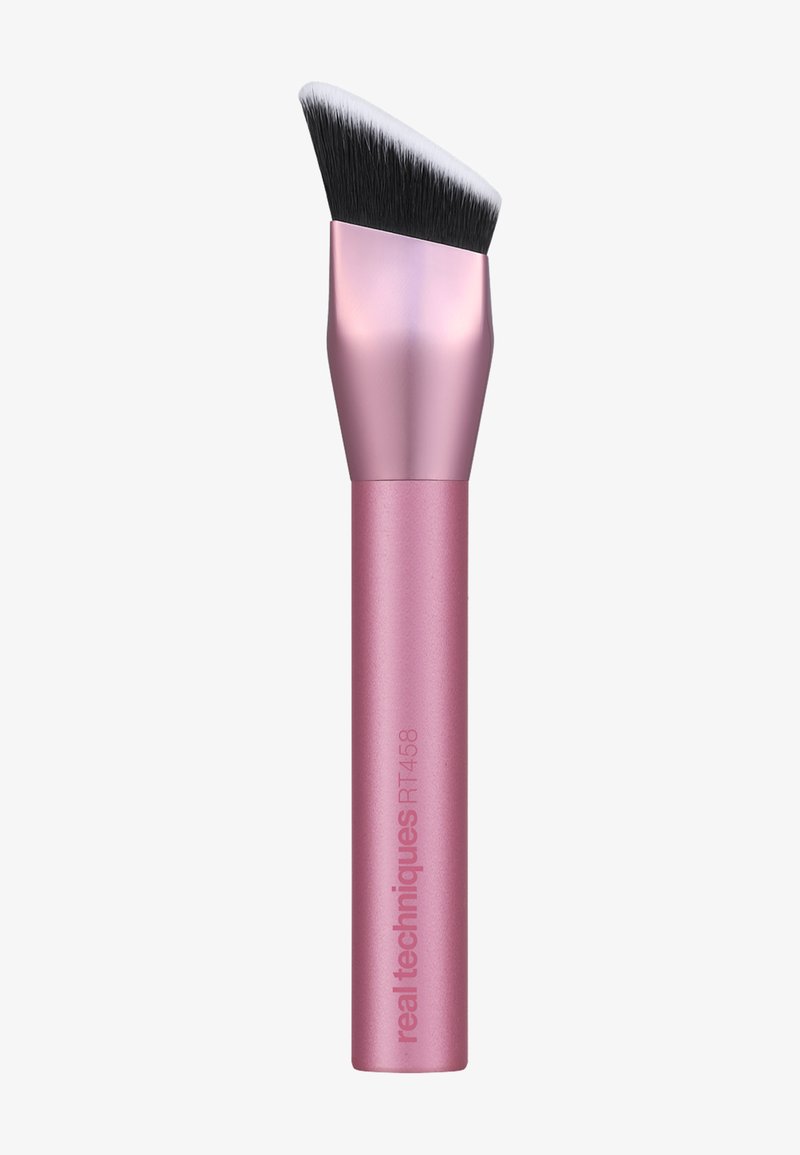Pinceau de maquillage incliné rose avec des poils synthétiques denses noirs et blancs, étiqueté "real techniques RT458" sur le manche.