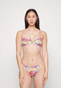 Conjunto de bikini colorido com um top sem alças com detalhe em laço e uma parte de baixo de cintura baixa. O tecido tem um padrão em espiral nas cores rosa, amarelo e roxo.