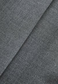 Tessuto grigio intrecciato con una superficie testurizzata, che presenta un motivo a zigzag e una finitura morbida, leggermente ruvida. Parti stratificate.