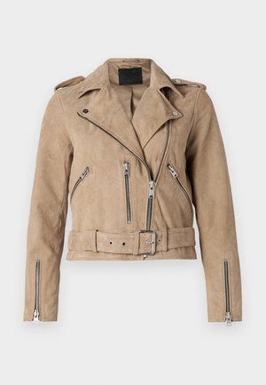 Veste de motard en daim beige avec plusieurs poches zippées, une taille ceinturée et un devant asymétrique avec épaulettes. Accents en métal argenté.
