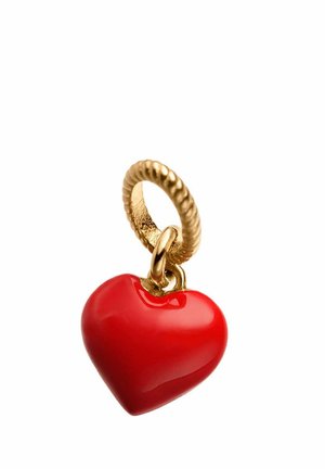 Bucle de oro con textura retorcida sosteniendo un brillante charm en forma de corazón rojo con superficie lisa sobre un fondo blanco.