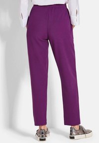 Paarse, rekbare broek met een rechte pijpdesign. Elastische tailleband en een gladde textuur. Gecombineerd met metallic zilveren sneakers.