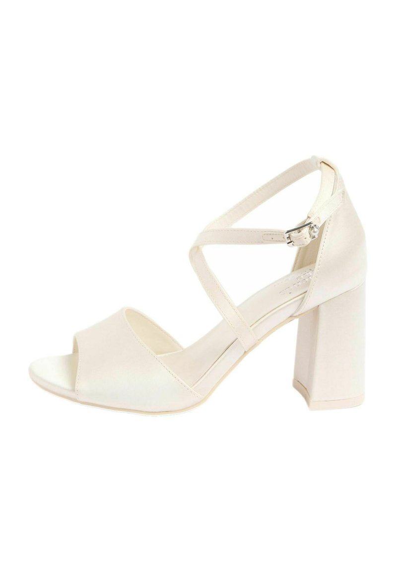 Bež satenska sandala z odprtim prstom in prečkasto zavezovanjem okoli gležnja. Ima kvadratno blok peto in gladek, sijoč zaključek.