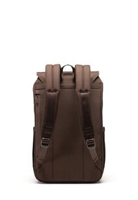 Sac à dos marron avec des bretelles rembourrées, poche zippée sur le côté et une poignée supérieure. Fabriqué en tissu durable avec une texture lisse et un design minimaliste.