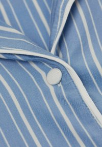 Blauwe stoffen overhemd met dunne witte strepen, voorzien van een ronde kraag en een witte knoop. Glad oppervlak met subtiele stikseldetails.