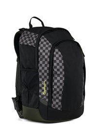 Sac à dos noir avec un motif à damier d'un côté, en tissu, plusieurs compartiments et une base verte. Logo notable en jaune.