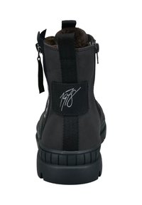 Stivale alla caviglia in pelle nera con finitura testurizzata, inserti elastici e colletto imbottito. Caratterizzato da un logo distintivo sul tallone e chiusura con zip.