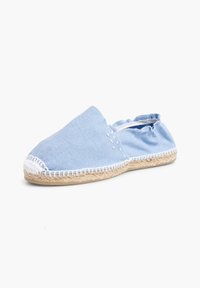 Espadrille en toile bleu clair avec un bout rond, des accents brodés blancs, une semelle en espadrille et un détail en tissu froncé au niveau du talon.