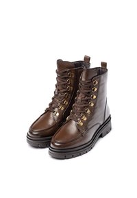 Bottes lacées en cuir marron avec un bout rond, quincaillerie dorée et une semelle en caoutchouc noir épaisse. Vue de face et de côté.