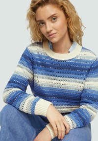 Blau-weiß gestreifter Pullover mit strukturierten Mustern, gerippten Bündchen und rundem Halsausschnitt, der verschiedene Blautöne in horizontalen Abschnitten zeigt.