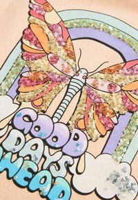 Färgglad fjärilsillustration med paljett detaljer i rosa, guld och grön, ovanpå texten "BRA DAGAR FRAMFÖR OSS" i bubbelformade bokstäver.