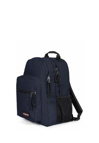 Námořnický modrý batoh vyrobený z odolné tkaniny; obsahuje dvě zipové přihrádky, síťovanou boční kapsu a polstrované ramenní popruhy.