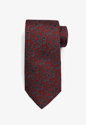 Red silk tie featuring a paisley pattern in black and blue tones, with a textured surface and a pointed end.