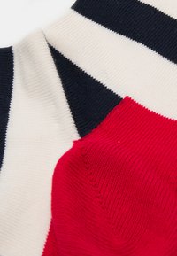 Red and navy striped cotton socks featuring a ribbed texture and contrasting sections, with a soft white background area.