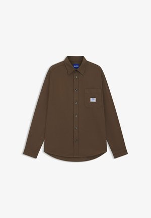 Chemise marron à manches longues en coton. Elle dispose d'un col plié, d'une patte de boutonnage à l'avant et d'une poche poitrine gauche avec un écusson logo.