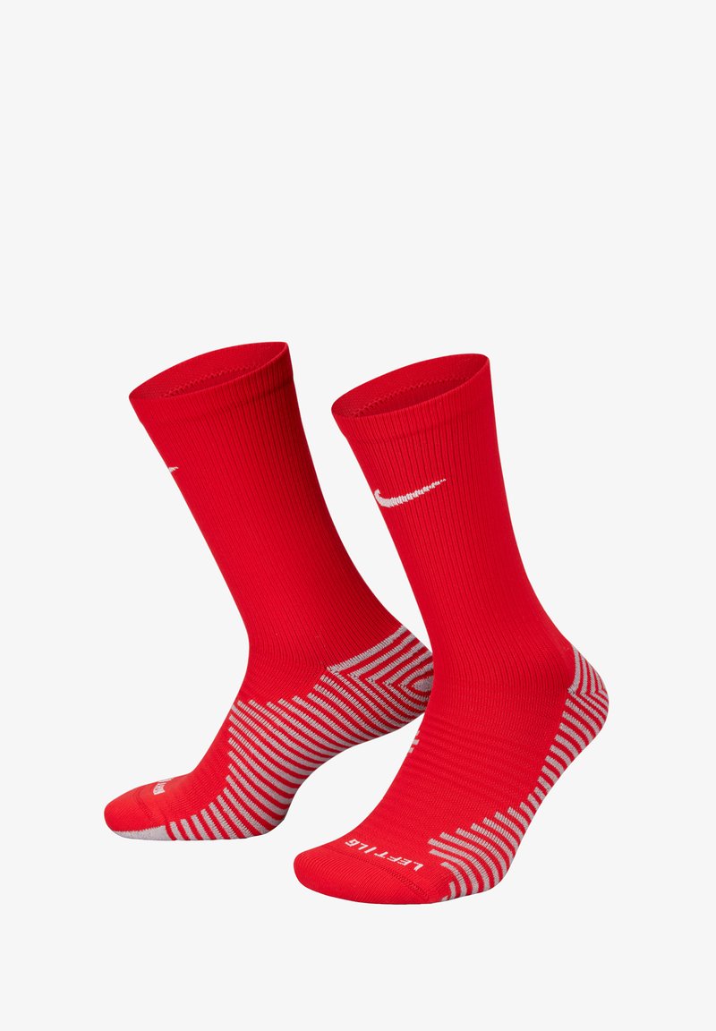Red athletic socks with ribbed texture, featuring a white Nike logo and a striped gray design on the sole. Mid-calf length.