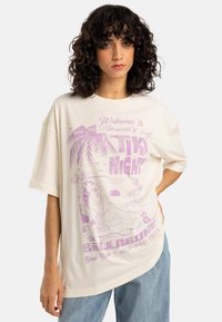 T-shirt oversize color crema con una stampa grafica viola raffigurante palme e una sirena, con maniche corte e una vestibilità rilassata.