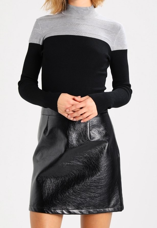 Schwarzer, gerippter Rollkragenpullover mit grauem Streifendesign. Kombiniert mit einem glänzenden schwarzen Kunstlederrock mit glatter Textur und Fronttaschen.