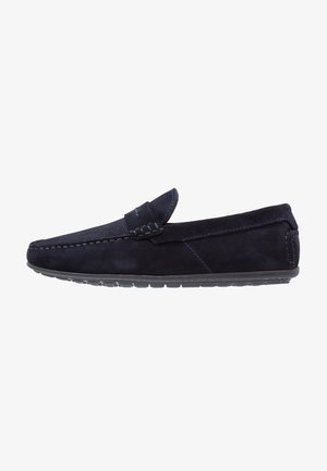 Mocassin pour homme en daim bleu foncé avec détails cousus et semelle en caoutchouc, vue latérale sur fond blanc.