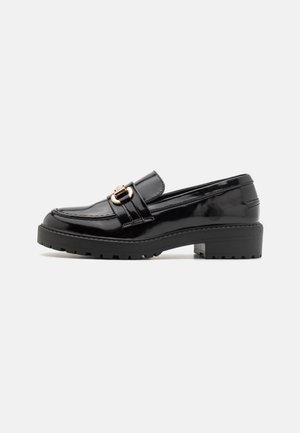 Sorte patentlæder loafers med lav blokhæl, der har en fremtrædende gold-tone spænde og struktureret, rillede ydersål.