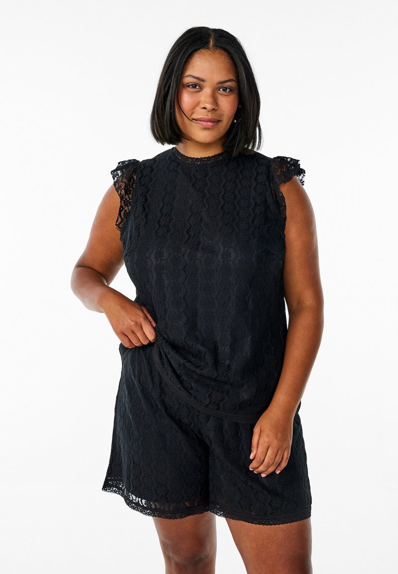 Czarny koronkowy kombinezon z krótkim rękawem i koronkowym wykończeniem, okrągłym dekoltem oraz luźnym krojem, w który wpleciony jest falisty wzór.
