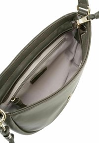 Sac à main en cuir vert olive avec un intérieur spacieux, comprenant une poche zippée et une doublure douce. Accentué de quincaillerie dorée.