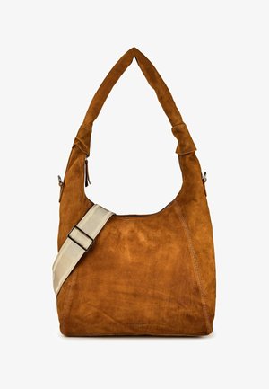 Bruine suède schoudertas met brede beige verstelbare band en zacht, slordig ontwerp tegen een witte achtergrond.