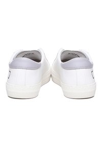 Sneakers bianchi con tomaia in pelle liscia, dettagli in grigio chiaro sul tallone e suola in gomma testurizzata. Design semplice con dettagli minimi.