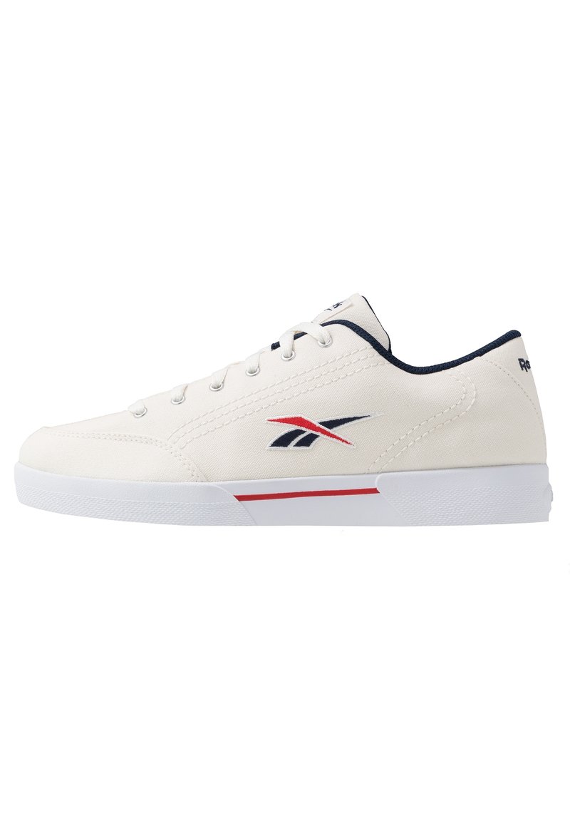Zapatilla de lona blanca con acentos en azul y rojo, que presenta seis ojetes, cordones planos, una suela acolchada y un logo en el costado.