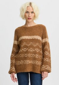 Maglione lavorato a maglia marrone con una finitura morbida e testurizzata. Presenta motivi geometrici color crema e maniche ampie, creando una vestibilità ampia e rilassata.