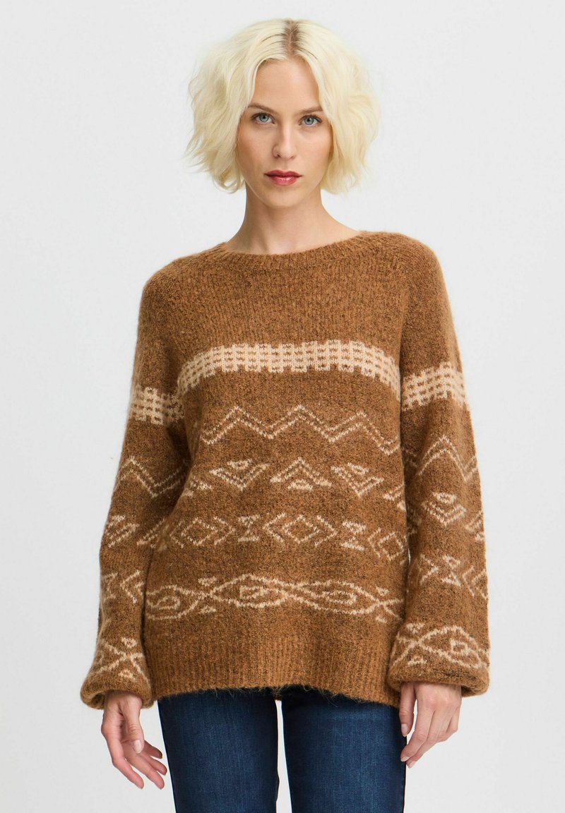 Maglione lavorato a maglia marrone con una finitura morbida e testurizzata. Presenta motivi geometrici color crema e maniche ampie, creando una vestibilità ampia e rilassata.