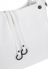 Witte leren handtas met een slank ontwerp, voorzien van twee lange hengsels en zwarte metalen accenten. Gladde textuur en subtiele stikdetails.