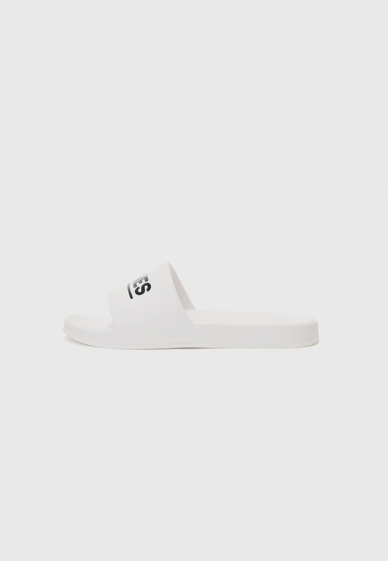 White slide sandals featuring a single strap with a black logo, flat sole, smooth texture, and rounded edges. Minimalist design.