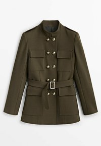 Veste militaire vert olive avec col montant, boutons dorés double boutonnage, quatre poches à rabats et taille cintrée avec boucle argentée.