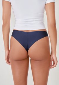 Marineblaue Bikinihose aus glattem, elastischem Material, mit niedrigem Schnitt und minimalistischer Form, ohne sichtbare Beschläge oder Muster.