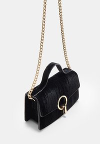 Borsa a tracolla in velluto nero con catena dorata, forma rettangolare, chiusura a patta e accento hardware circolare sulla parte frontale.