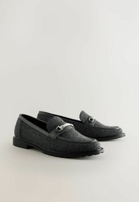 Grijze felt loafers met zwarte leren accenten, een decoratieve band met metalen hardware en een textuur rubberen zool. Klasse, laag profiel ontwerp.