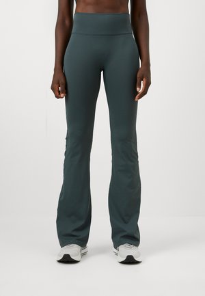 Teal uitlopende leggings met een hoge taille, gemaakt van zachte, rekbare stof. Ze hebben een gladde textuur en minimale stikdetails.