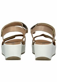 Brown leather sandals with adjustable straps, white platform soles, and a smooth texture. Back view shows two cross straps and buckle details.
