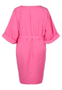 Różowa sukienka z krótkim rękawem o luźnym kroju, z wiązanym paskiem w talii i gładkim, lekkim materiałem. Minimalistyczny design; brak wzorów.